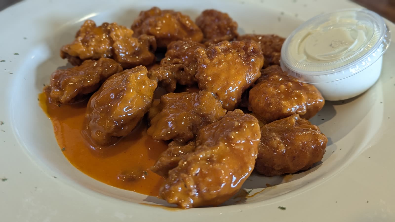 Sauced wings with dipping sauce at Bruno's